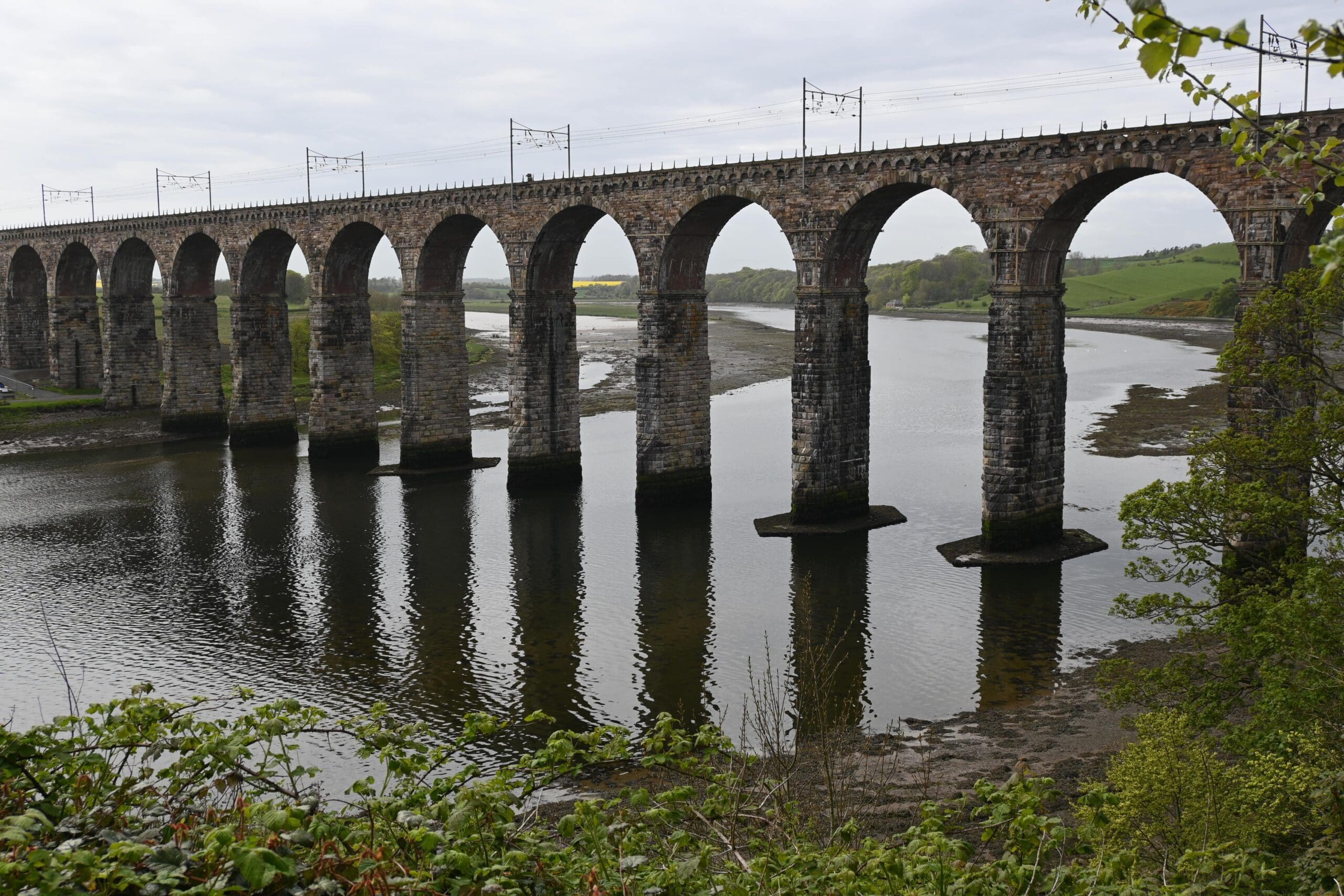 A tall brick viaduct across a river