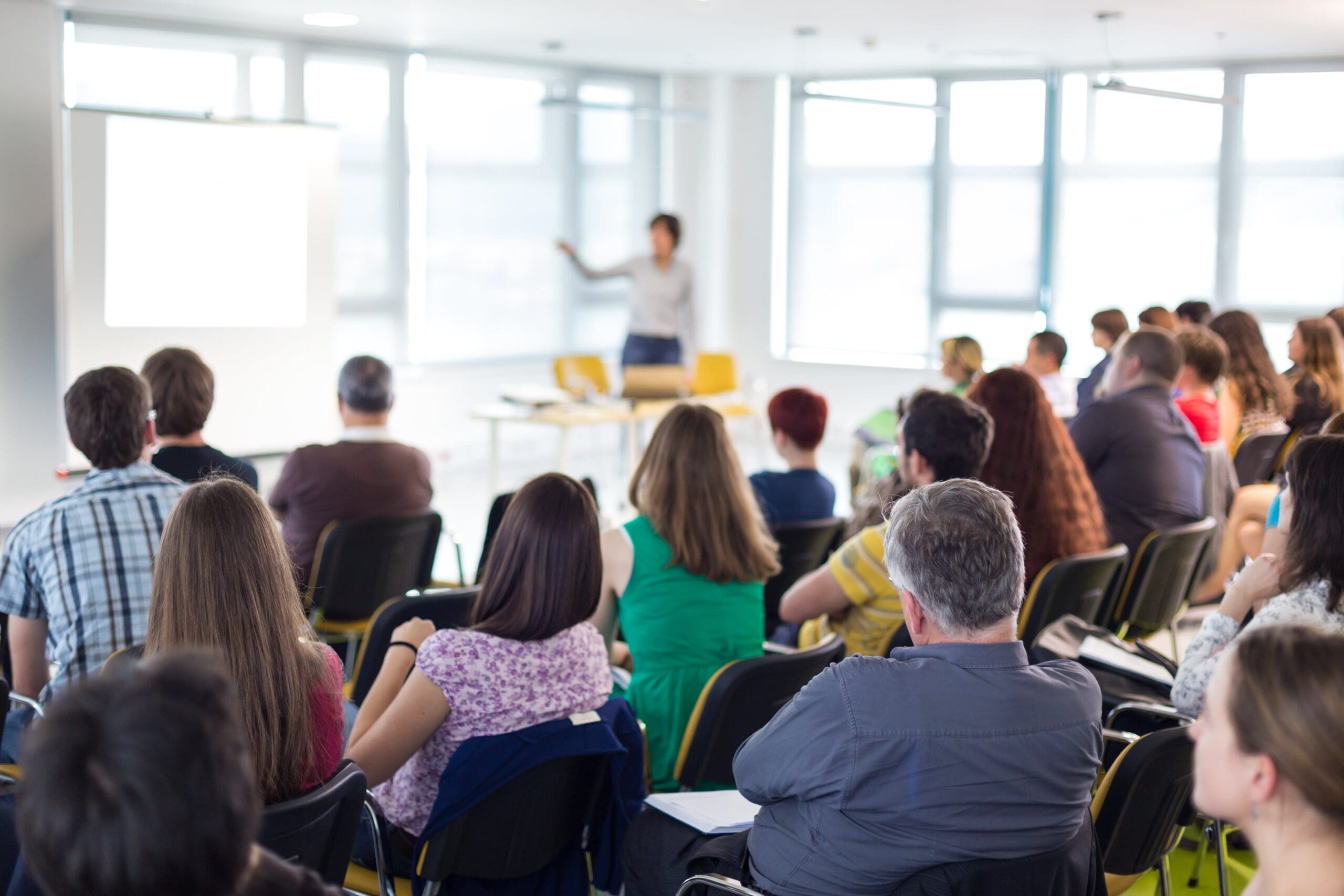 Tutor stood up near the whiteboard, teaching a room full of course attendees